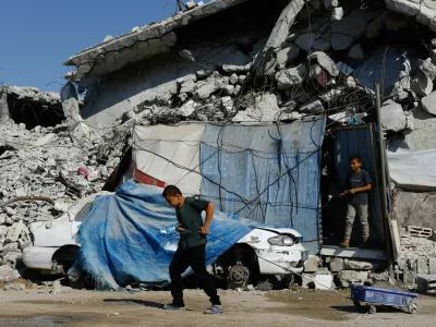 A young Palestinian pulls a wheeled cart near rubble from buildings destroyed during the war, at Jabalia refugee camp in the northern Gaza Strip, August 5, 2026. REUTERS/Mahmoud Issa