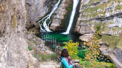 Alpine waterfall Savica in the nation park Triglav, Slovenia. Mother carrying baby in front. / Foto: Blazekg Getty Images