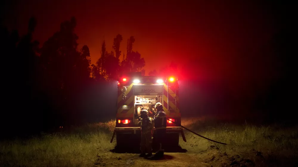 Firefighters prepare to fight flames caused by wildfires in Puren, Chile, Saturday, Saturday, Feb. 4, 2023. Forest fires are spreading in southern and central Chile, triggering evacuations and the declaration of a state of emergency in some regions. (AP Photo/Matias Delacroix)