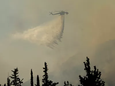 A firefighting helicopter makes a water drop as a wildfire burns near Haidari in Athens, Greece, July 31, 2026. REUTERS/Louiza Vradi