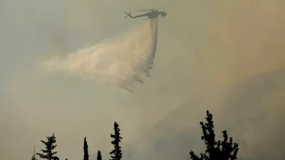 A firefighting helicopter makes a water drop as a wildfire burns near Haidari in Athens, Greece, July 31, 2026. REUTERS/Louiza Vradi