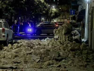 A municipal police vehicle is parked behind rubble and a damaged car after a magnitude 4.7 earthquake struck the Campi Flegrei area, on Via Pergolesi in Pozzuoli, Italy, July 31, 2026. REUTERS/Salvatore Laporta