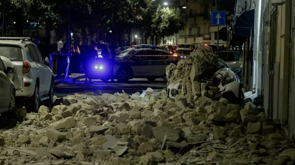 A municipal police vehicle is parked behind rubble and a damaged car after a magnitude 4.7 earthquake struck the Campi Flegrei area, on Via Pergolesi in Pozzuoli, Italy, July 31, 2026. REUTERS/Salvatore Laporta