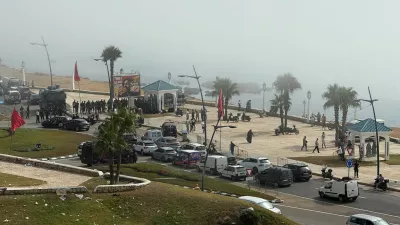 Security forces stand guard in Fnideq, Morocco, August 1, 2026, as migrants gather after crossing from the Spanish enclave of Ceuta to the Moroccan side of the border. Picture taken using a mobile phone. REUTERS/Stringer