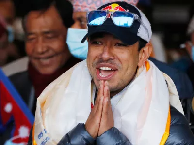 FILE - Nirmal Purja, one of the team member of the all-Nepalese mountaineering team that became the first to scale Mount K2 in winter, gestures as the team arrives at Tribhuwan International airport in Kathmandu, Nepal, Jan. 26, 2021. (AP Photo/Niranjan Shrestha, File)