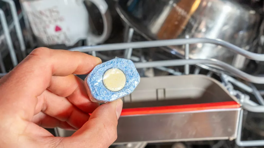 Bavaria, Germany - July 2, 2026: A hand holds a dishwasher tablet in front of a loaded dishwasher with an upper rack. The image shows the preparation for a dishwasher cycle and symbolizes hygienic cleaning, cleanliness, and efficient household care. *** Eine Hand h&auml;lt einen Sp&uuml;lmaschinentab vor den beladenen Geschirrsp&uuml;ler mit Oberkorb, bzw. Sp&uuml;lmaschinen-Korb. Das Bild zeigt die Vorbereitung eines Sp&uuml;lgangs und steht f&uuml;r hygienische Reinigung, Sauberkeit und effiziente Haushaltspflege.,Image: 1113982284, License: Rights-managed, Restrictions: imago is entitled to issue a simple usage license at the time of provision. Personality and trademark rights as well as copyright laws regarding art-works shown must be observed. Commercial use at your own risk., Model Release: no 