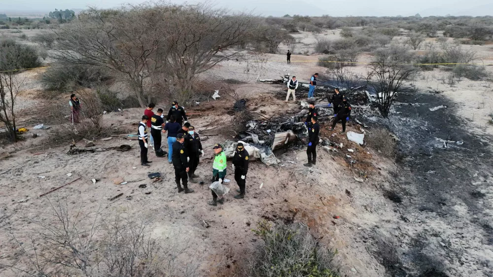 Police inspect the wreckage of a plane that crashed during a sightseeing flight carrying tourists over the Nazca Lines in Peru, Saturday, Aug. 1, 2026. (AP Photo/Genry Bautista)