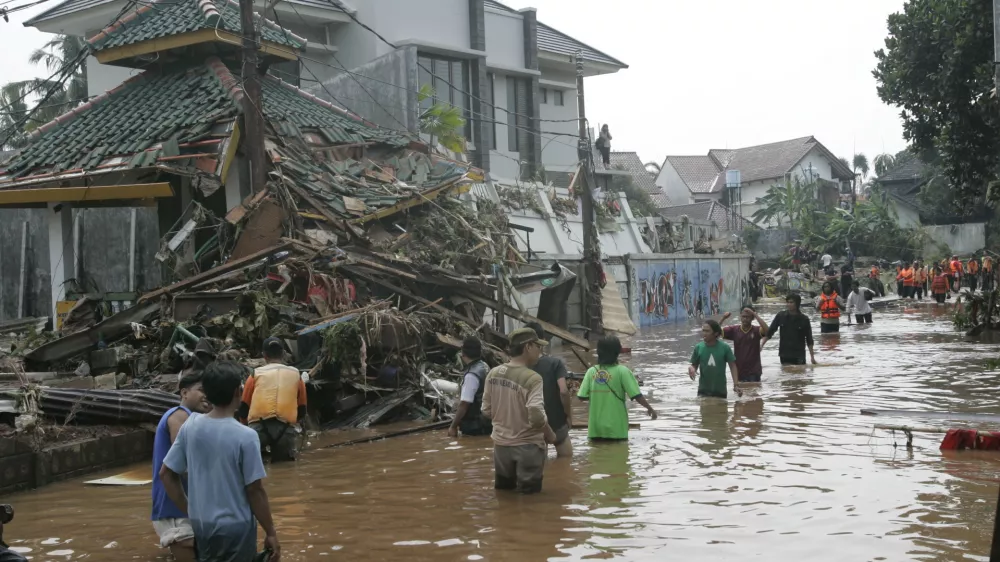 Residents wade through flood caused by burst dam in Jakarta, Indonesia, Friday, March 27, 2009. A dam burst in the outskirts of Indonesia's capital before dawn Friday, sending a flash flood into a crowded residential neighborhood, submerging hundreds of houses and killing at least 50 people, officials said.(AP Photo/Tatan Syuflana)