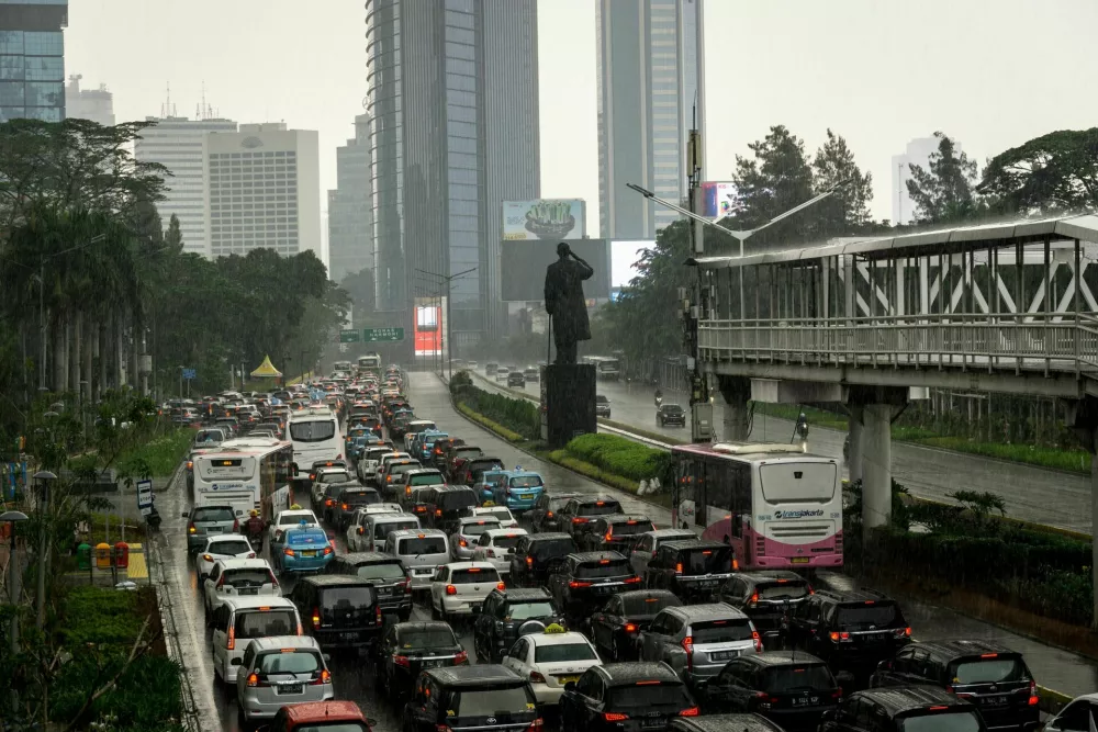 Jakarta, Indonesia - November 16 2018: Traffic jam along the Sudirman road in the heart of Jakarta business district on a rainy day with Transjakarta bus on their own busway.