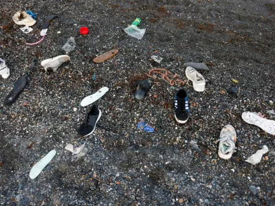 Shoes belonging to migrants lie on El Tarajal beach, amid mass crossings of migrants on foot and by sea from Morocco into Spanish territory, in Ceuta, Spain, July 31, 2026. REUTERS/Jon Nazca