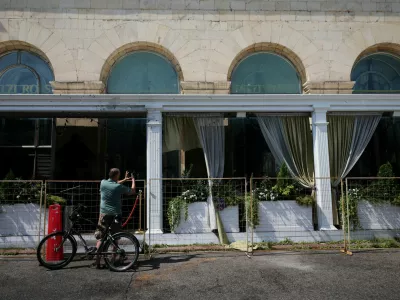A cyclist takes a picture of the fenced-off Balzi Rossi Italian restaurant following a deadly bomb explosion in central Moscow, Russia, August 2, 2026. Russia's National Anti-Terrorism Committee said the previous day that the bomb was carried by an unidentified woman who attempted to enter the restaurant and was stopped by a security guard. REUTERS/Anastasia Barashkova