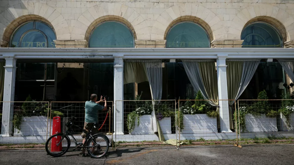 A cyclist takes a picture of the fenced-off Balzi Rossi Italian restaurant following a deadly bomb explosion in central Moscow, Russia, August 2, 2026. Russia's National Anti-Terrorism Committee said the previous day that the bomb was carried by an unidentified woman who attempted to enter the restaurant and was stopped by a security guard. REUTERS/Anastasia Barashkova