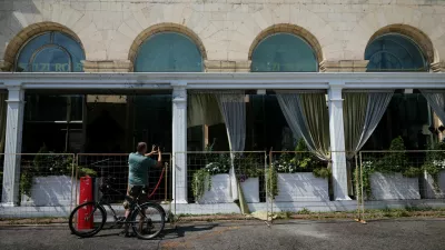 A cyclist takes a picture of the fenced-off Balzi Rossi Italian restaurant following a deadly bomb explosion in central Moscow, Russia, August 2, 2026. Russia's National Anti-Terrorism Committee said the previous day that the bomb was carried by an unidentified woman who attempted to enter the restaurant and was stopped by a security guard. REUTERS/Anastasia Barashkova