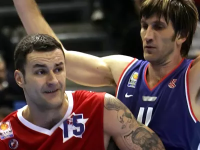 Serbia-Montenegro player Milan Gurovic, left, challenges for the ball with Croatia's Davor Marcelic during the Adriatic League basketball match between Red Star Belgrade and Cibona Zagreb, Saturday, Nov. 12, 2005, in Belgrade. Tattoo on the arm of Gurovic depicts the former ultra-nationalist Serb World War II leader Draza Mihailovic. (AP Photo/Darko Vojinovic)