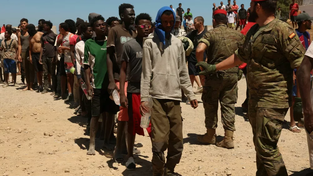 Migrants who crossed into Ceuta from Morocco queue for water provided by the Spanish military, following deadly mass crossings of migrants on foot and by sea from Morocco into Spanish territory, in Ceuta, Spain, August 2, 2026. REUTERS/Violeta Santos Moura