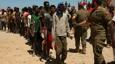 Migrants who crossed into Ceuta from Morocco queue for water provided by the Spanish military, following deadly mass crossings of migrants on foot and by sea from Morocco into Spanish territory, in Ceuta, Spain, August 2, 2026. REUTERS/Violeta Santos Moura
