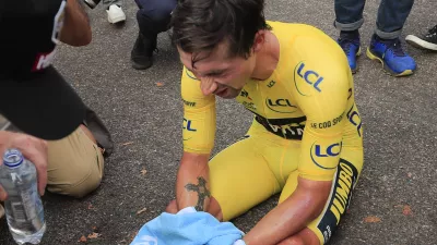 Slovenia's Primoz Roglic sits on the road after losing the overall leader's yellow jersey in stage 20 of the Tour de France cycling race, an individual time trial over 36.2 kilometers (22.5 miles), from Lure to La Planche des Belles Filles, France, Saturday, Sept. 19, 2020. (Christophe Petit-Tesson/Pool via AP)