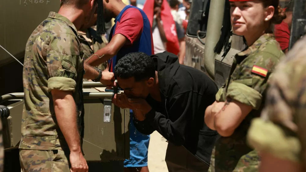A migrant who crossed into Ceuta from Morocco drinks water provided by the Spanish military, following deadly mass crossings of migrants on foot and by sea from Morocco into Spanish territory, in Ceuta, Spain, August 2, 2026. REUTERS/Violeta Santos Moura