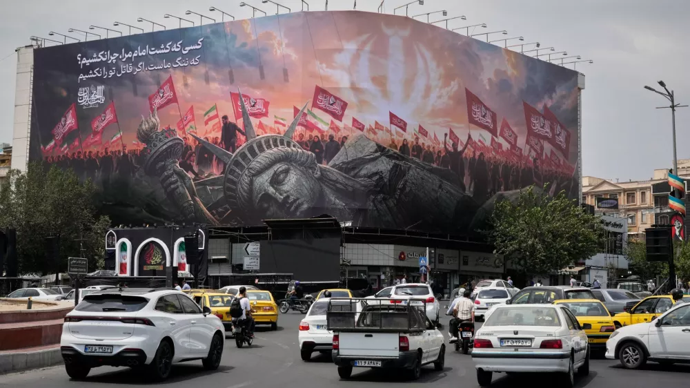 A billboard depicting a fallen Statue of Liberty and crowds carrying Iranian and Shiite flags overlooks Revolution Square as traffic drives by in Tehran, Iran, Monday, Aug. 3, 2026. (AP Photo/Vahid Salemi)