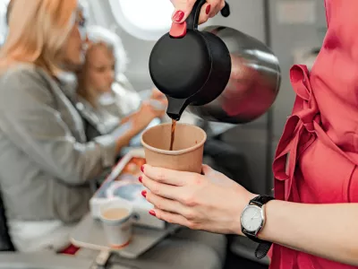 Cropped photo of stewardess holding teapot and paper cup stock photo / Foto: Yakobchukolena Getty Images/istockphoto