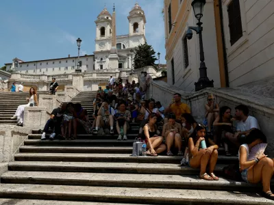 People sit in the shade on the Spanish steps during a heatwave, as temperatures are expected to rise further in the coming days, in Rome, Italy August 3, 2026. REUTERS/Remo Casilli   TPX IMAGES OF THE DAY