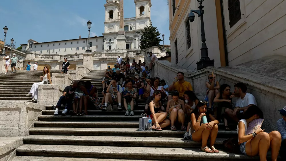 People sit in the shade on the Spanish steps during a heatwave, as temperatures are expected to rise further in the coming days, in Rome, Italy August 3, 2026. REUTERS/Remo Casilli   TPX IMAGES OF THE DAY