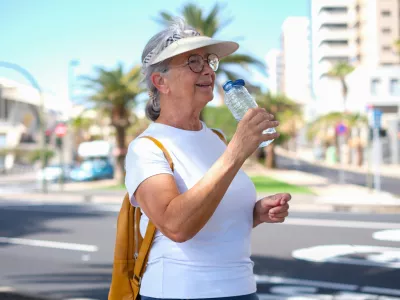 Active elderly tourist woman casual dressed drinks from a bottle water along the urban street, city life in background / Foto: Lucigerma Getty Images