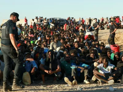Migrants wait in line to receive food and beverage from the Red Cross, following mass crossings of migrants on foot and by sea from Morocco into Spanish territory, in Ceuta, Spain, August 3, 2026. REUTERS/Violeta Santos Moura