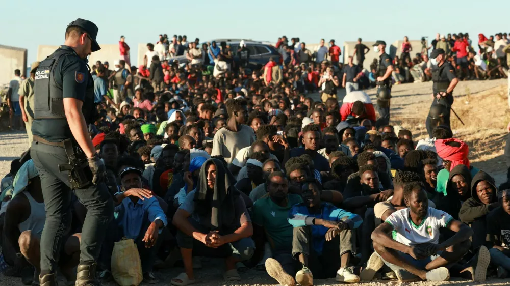 Migrants wait in line to receive food and beverage from the Red Cross, following mass crossings of migrants on foot and by sea from Morocco into Spanish territory, in Ceuta, Spain, August 3, 2026. REUTERS/Violeta Santos Moura