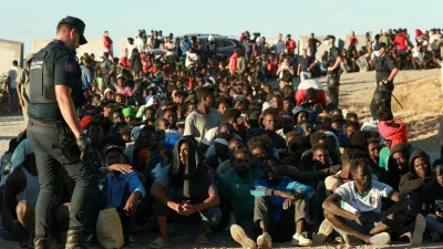 Migrants wait in line to receive food and beverage from the Red Cross, following mass crossings of migrants on foot and by sea from Morocco into Spanish territory, in Ceuta, Spain, August 3, 2026. REUTERS/Violeta Santos Moura