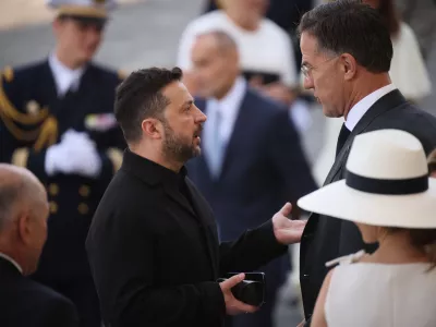 Ukraine's President Volodymyr Zelensky, center left, listens to NATO Secretary-General Mark Rutte as they arrive for the Bastille Day military parade on the Champs-Elysees avenue in Paris, Tuesday, July 14, 2026. (AP Photo/Thomas Padilla)