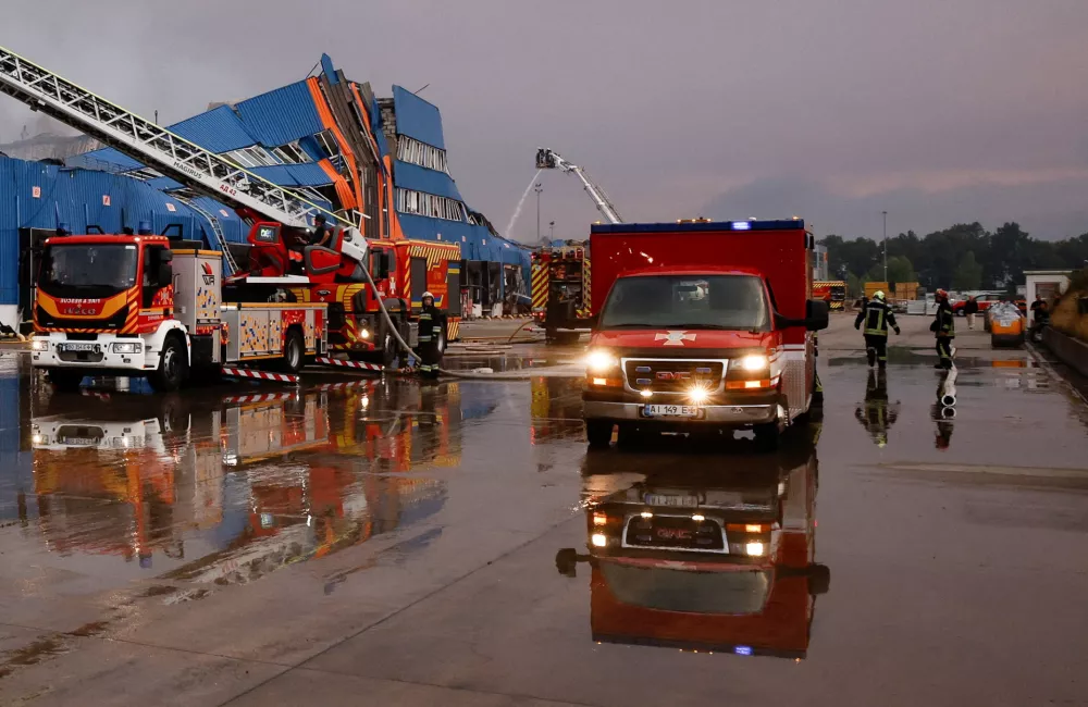 Firefighters work at a logistics hub of the Ukrainian online retailer, Rozetka, after it was struck during a night of Russian missile and drone attacks, amid Russia's attack on Ukraine, in the Kyiv region, Ukraine, August 5, 2026. REUTERS/Thomas Peter