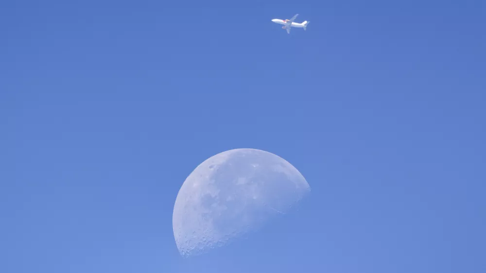A commercial aircraft passes in front of the Moon above Sofia, Bulgaria, on August 5, 2026. The photograph was taken as astronomers and skywatchers observed the widely anticipated impact of a SpaceX Falcon 9 upper stage with the lunar surface during a closely followed space event.