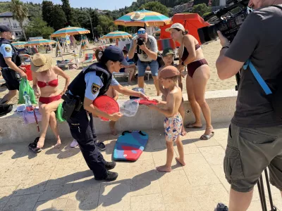 Portoroz, plaza.Preventivna akcija slovenske policije, v okviru katere so kopalce na plazi opozarjali na nevarnost tatvin in drugih kaznivih dejanj.