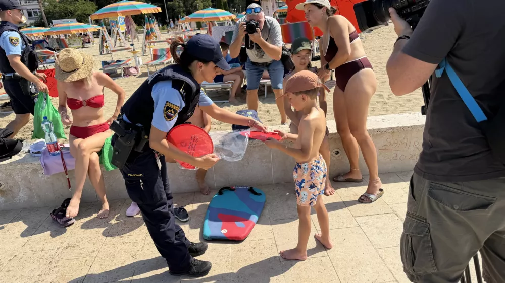 Portoroz, plaza.Preventivna akcija slovenske policije, v okviru katere so kopalce na plazi opozarjali na nevarnost tatvin in drugih kaznivih dejanj.