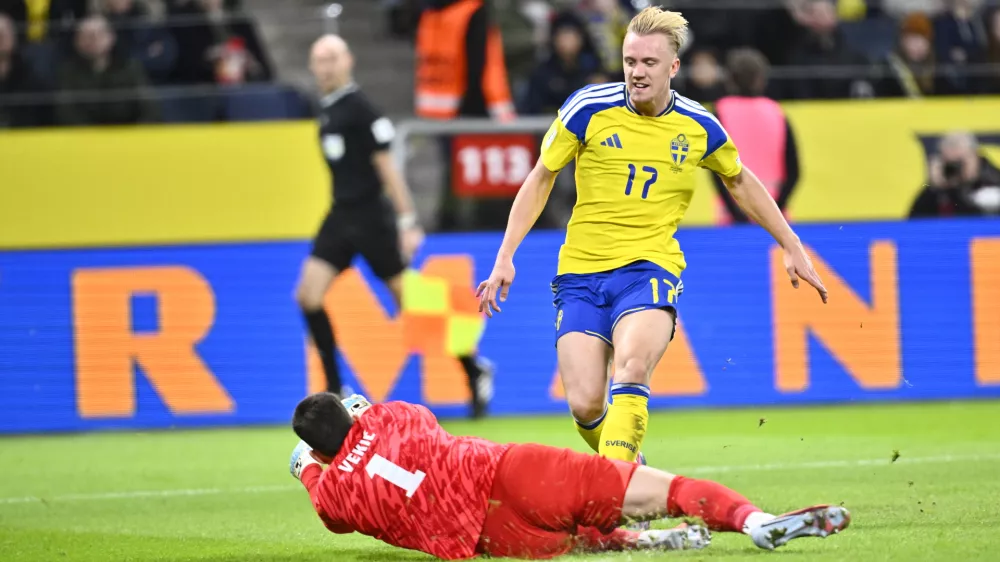 Slovenia's goalkeeper Igor Vekic, left, blocks a shot by Sweden's Isac Lidberg during the 2026 World Cup qualifier group B soccer match between Sweden and Slovenia, in Stockholm, Tuesday, Nov. 18, 2025. (Pontus Lundahl/TT News Agency via AP)
