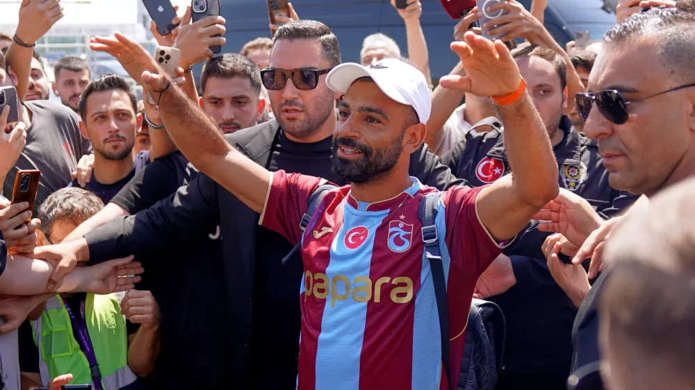 Egypt's Mohamed Salah wearing his new Trabzonspor team jersey gestures to supporters as he arrives at the airport in Istanbul, Turkey, Wednesday, Aug. 5, 2026. (Samet Yalcin/DIA Photo via AP)