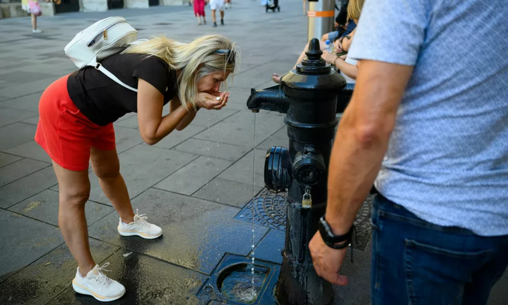 A person drinks at a public fountain near St. Stephen's Cathedral during a heatwave in Vienna, Austria, August 3, 2026. REUTERS/Elisabeth Mandl