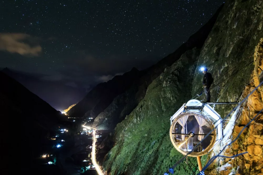 This is the worlds first hanging lodge suspended 1,200ft off the ground in Perus Sacred Valley of Cusco.Boasting stunning panoramic views, the Skylodge Adventure Suites capsules can fit up to eight people and each of the three luxurious cabins come complete with four beds, a dinning area and a private bathroom with an ecological toilet.Intrepid travelers have to climb the mountain to get to the capsule, via a secure climbing path which is fit for beginners, and are rewarded with 300 degree view of the majestic Sacred Valley once at the top.Measuring 24ft in length and 8ft in height and width, the pods are hand crafted out of aerospace aluminum and weather resistant polycarbonate.It costs around USD$450 per person for a nights stay, and the price includes a sunrise breakfast enjoyed from the comfort of your personal capsule, as well as a gourmet dinner served up with wine.At the end of the stay, guests get back down the mountain via one of seven zip lines.Skylodge Adventure Suites became the worlds first hanging lodges after launching in June 2013. It was opened by a small company called Natura Vive, a group of young entrepreneurs whose philosophy was to create a mountain experience that people of all ages and abilities can enjoy.29 Jan 2018Pictured: Skylodge Adventure Suites are comprised of three luxurious cabins which hang 1,200ft in the air on a mountainside in Perus Sacred Valley of Cusco.,Image: 361729634, License: Rights-managed, Restrictions: World Rights, Model Release: no, Pictured: Skylodge Adventure Suites are comprised of three luxurious cabins which hang 1,200ft in the air on a mountainside in Perus Sacred Valley of Cusco 