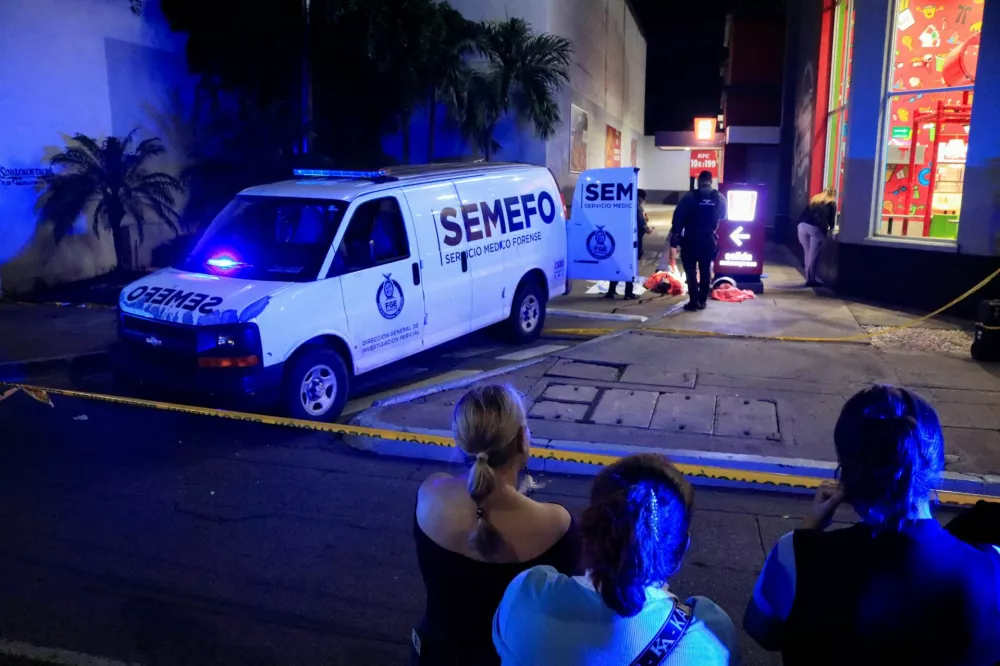 Onlookers stand behind a police cordon as forensic technicians and police officers work at the crime scene where Mexican social media influencer Cesar Gastelum, known for his comedy videos and followed by nearly 600,000 people on TikTok, was shot and killed while livestreaming with friends outside a fast-food restaurant in Culiacan, Sinaloa state, Mexico, August 4, 2026. REUTERS/Jesus Bustamante