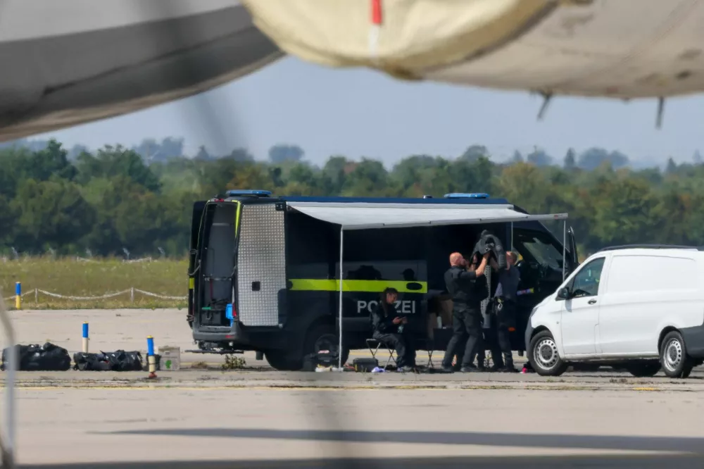 Police officers work in the vicinity of an Antonov cargo plane, near which a drone was found, at Leipzig/Halle Airport in Schkeuditz, Germany, August 5, 2026, after the police said explosives experts examined a drone near a runway, and after a DHL cargo aircraft hit an unknown object as it was climbing away from the airport overnight, prompting an unscheduled landing in Hanover, according to a source familiar with the incident. REUTERS/Axel Schmidt