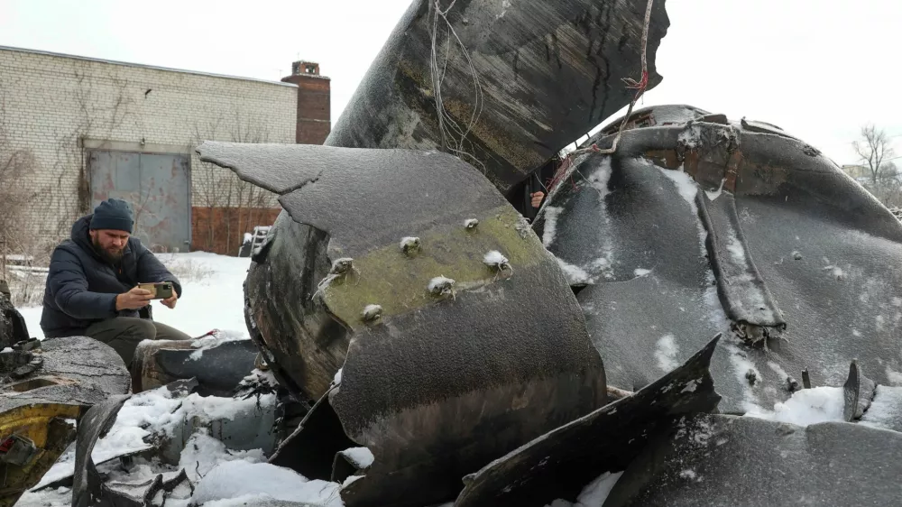 FILE PHOTO: A man photographs parts of an unidentified missile, which Ukrainian authorities believe to be made in North Korea and was used in a strike in Kharkiv earlier this week, amid Russia's attack on Ukraine, in Kharkiv, Ukraine January 6, 2024. REUTERS/Vyacheslav Madiyevskyy/File Photo