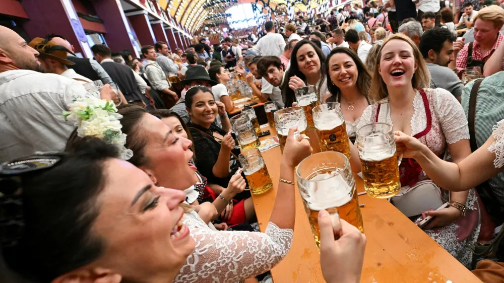Visitors raise their beer mugs during the official opening day of the 190th Oktoberfest, the world's largest beer festival in Munich, Germany, September 20, 2025. REUTERS/Angelika Warmuth