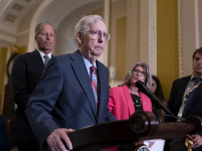 Senate Minority Leader Mitch McConnell, R-Ky., joined at left by Sen. John Thune, R-S.D., and Sen. Joni Ernst, R-Iowa, seems to freeze at the microphones as he arrived for a news conference at the Capitol in Washington, Wednesday, July 26, 2023. McConnell went to his office for a few minutes and returned to speak with reporters. (AP Photo/J. Scott Applewhite)