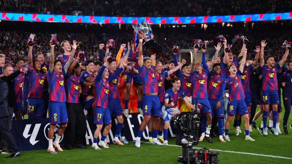 Barcelona's Ronald Araujo lifts the trophy after defeating Real Madrid 2-0 to win the Spanish La Liga soccer championship with three rounds to spare, in Barcelona, Spain, Sunday, May 10, 2026. (AP Photo/Joan Mateu Parra)