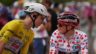 Slovenia's Tadej Pogacar, wearing the overall leader's yellow jersey, talks to Denmark's Jonas Vingegaard, wearing the best climber's dotted jersey, before the start of the eleventh stage of the Tour de France cycling race with start in Vichy and finish in Nevers, France, Wednesday, July 15, 2026. (AP Photo/Mosa'ab Elshamy)