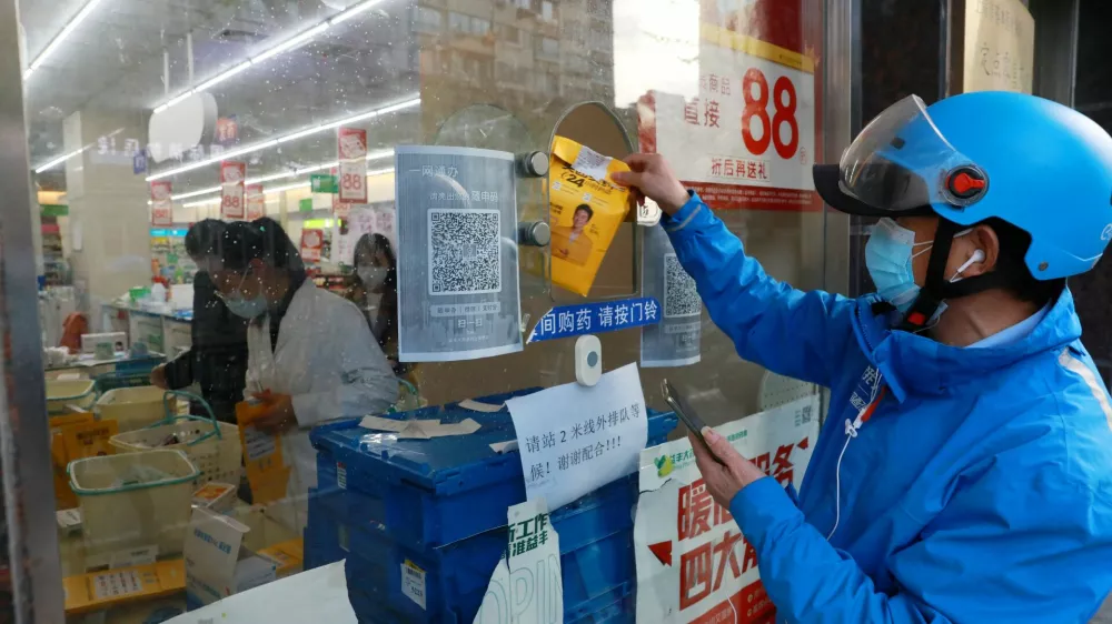 A delivery worker picks up a medicine order from a pharmacy in Huangpu district, amid the coronavirus disease (COVID-19) outbreak in Shanghai, China April 17, 2022. Picture taken April 17, 2022. China Daily via REUTERS ATTENTION EDITORS - THIS IMAGE WAS PROVIDED BY A THIRD PARTY. CHINA OUT.