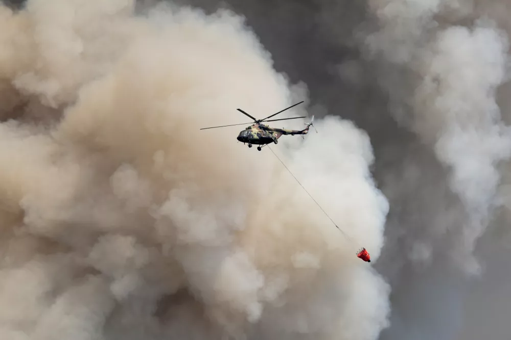 A Serbian Army helicopter battles a fire in Deliblatska Pescara (Deliblato Sands), near the village of Sumarak, 70 kilometers north-west of Belgrade, Serbia, Friday, Aug. 7, 2026. (AP Photo/Darko Vojinovic)