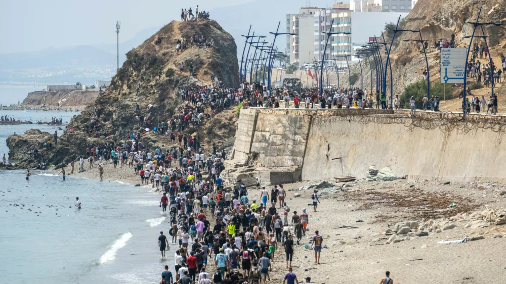 People walk on a beach after attempting to cross from the Moroccan northern town of Fnideq to the Spanish enclave of Ceuta, Friday, July 31, 2026. (AP Photo)