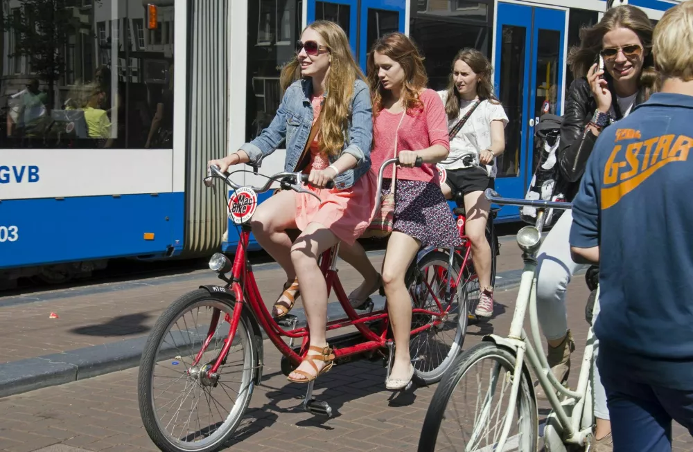 Amsterdam, Holland - August 8, 2013: Girls on rented bikes navigate through an Amsterdam street on August 8, 2013 in Amsterdam, Holland / Foto: Thehague
